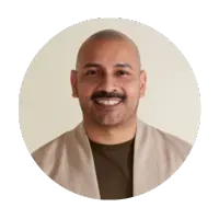 A man with a mustache is smiling in a circle.