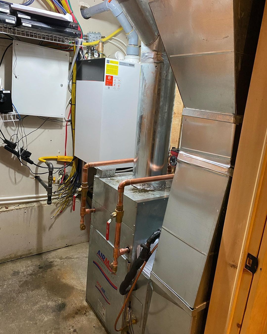 A room with a gas heater and a water heater in it.