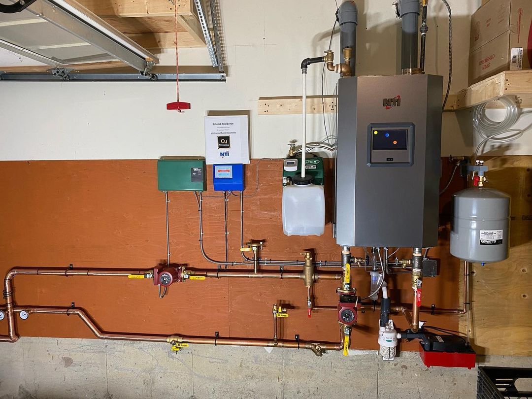 A water heater is hanging on the wall in a garage.