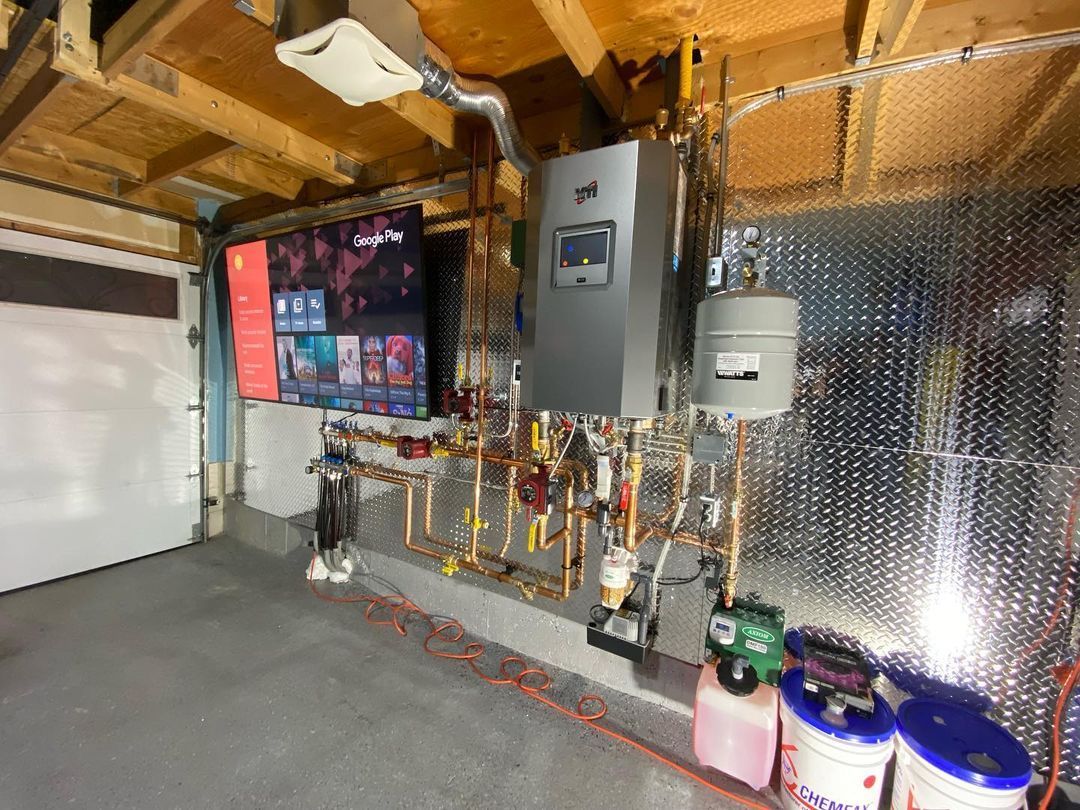 A garage with a lot of pipes and a tv on the wall.