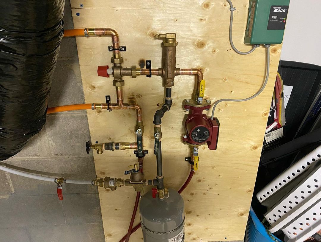 A bunch of pipes are connected to a wooden wall.