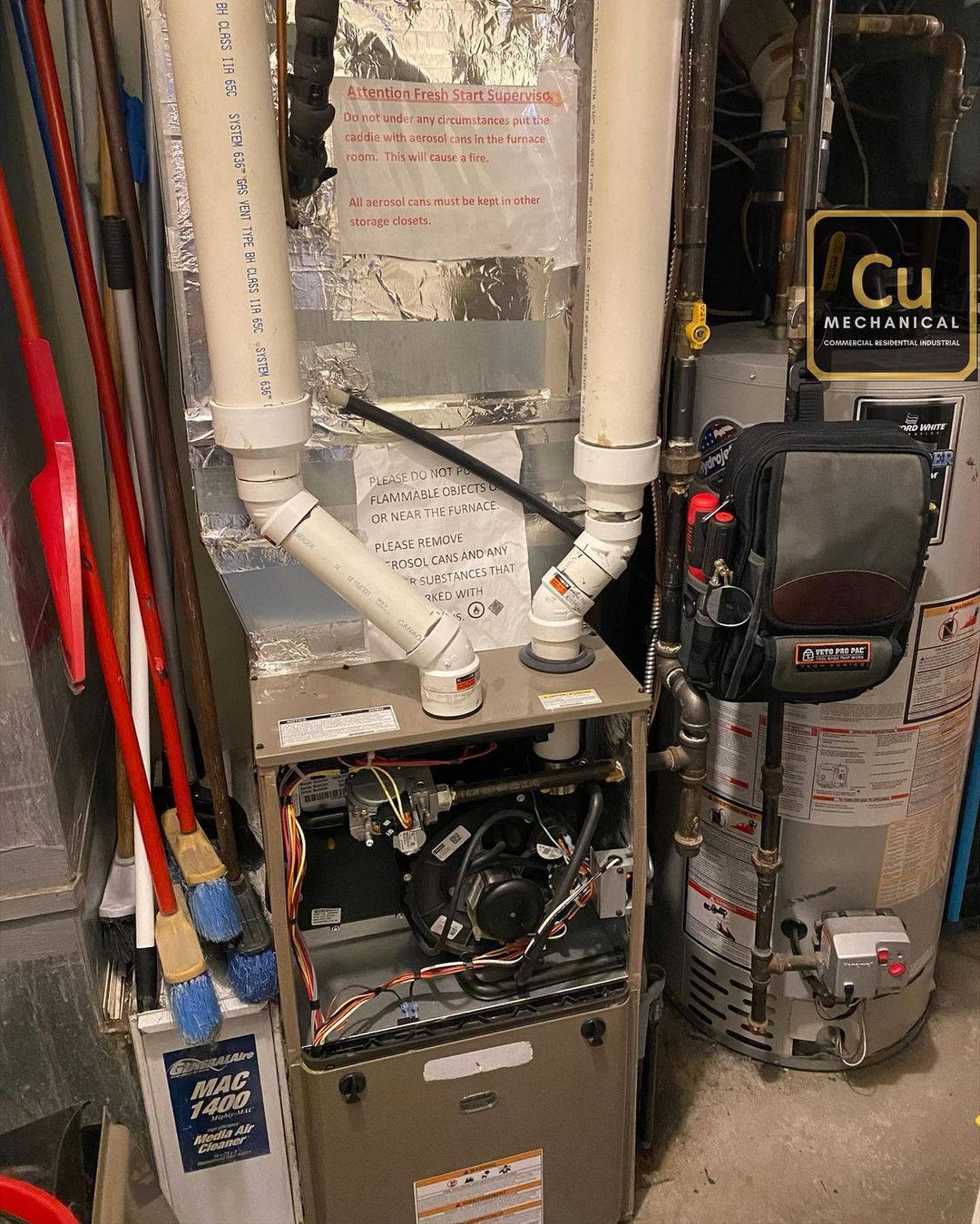 A heating and cooling system is sitting in a basement next to a water heater.