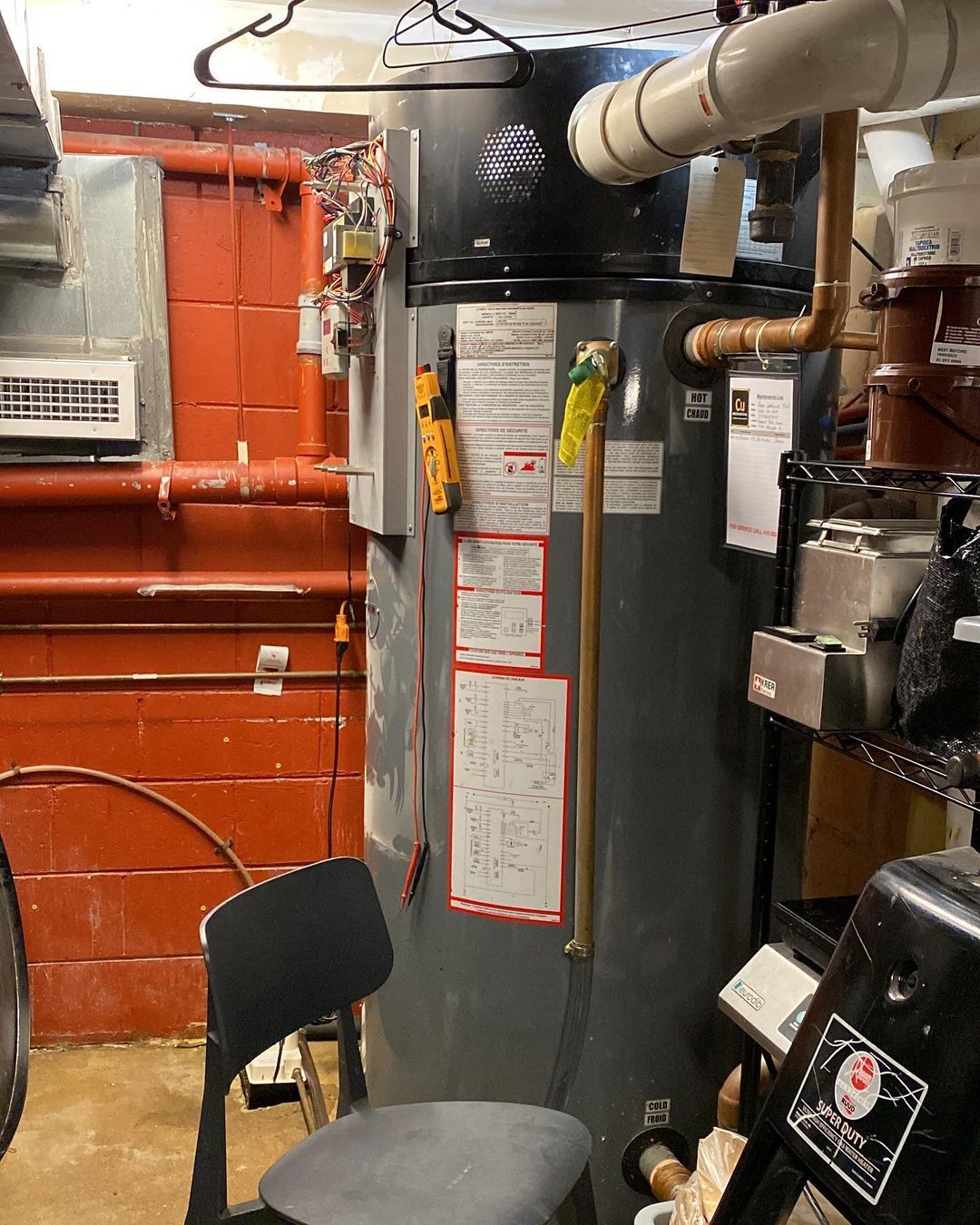 A room with a chair and a water heater in it