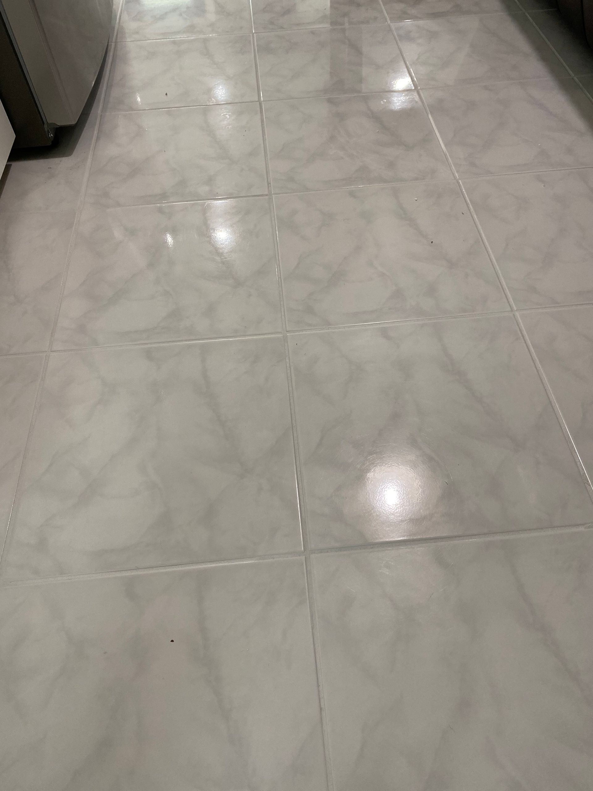 White marble tile flooring with reflections.