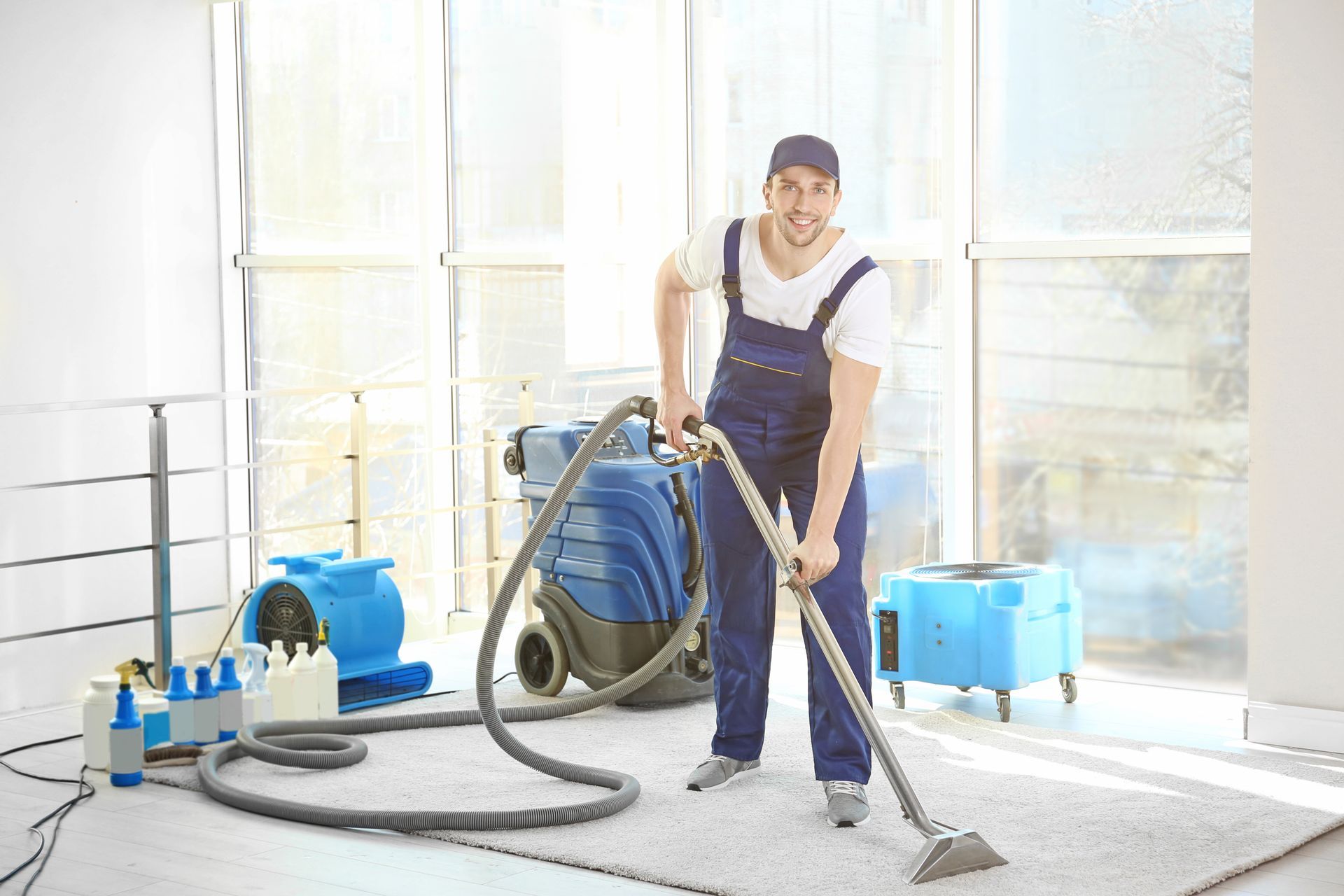 A carpet cleaning employee removing dirt from a carpet in an office.