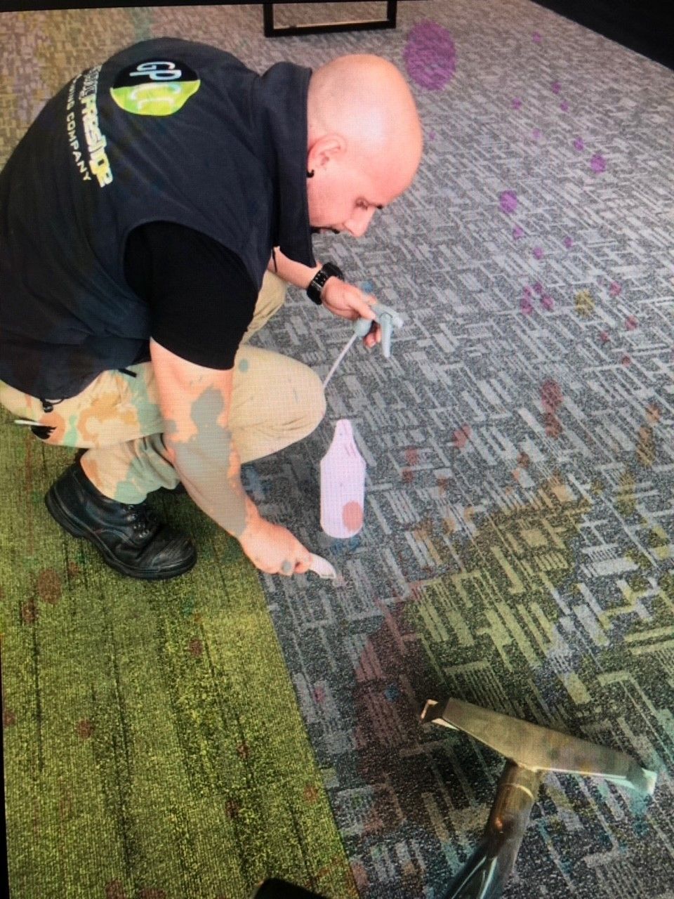 A man is cleaning a carpet with a spray bottle