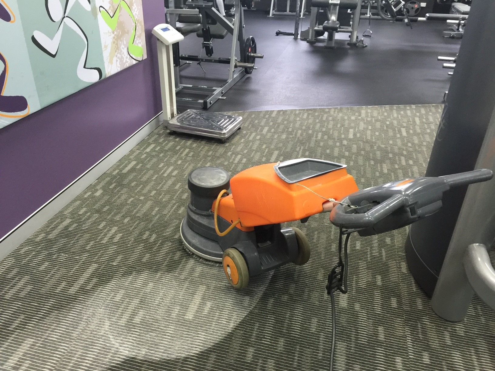 A man is using a vacuum cleaner to clean a carpet.
