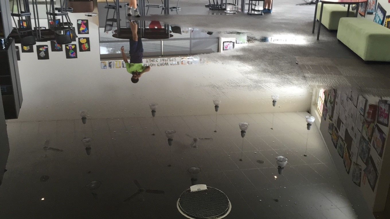 A flooded room with a manhole cover on the floor