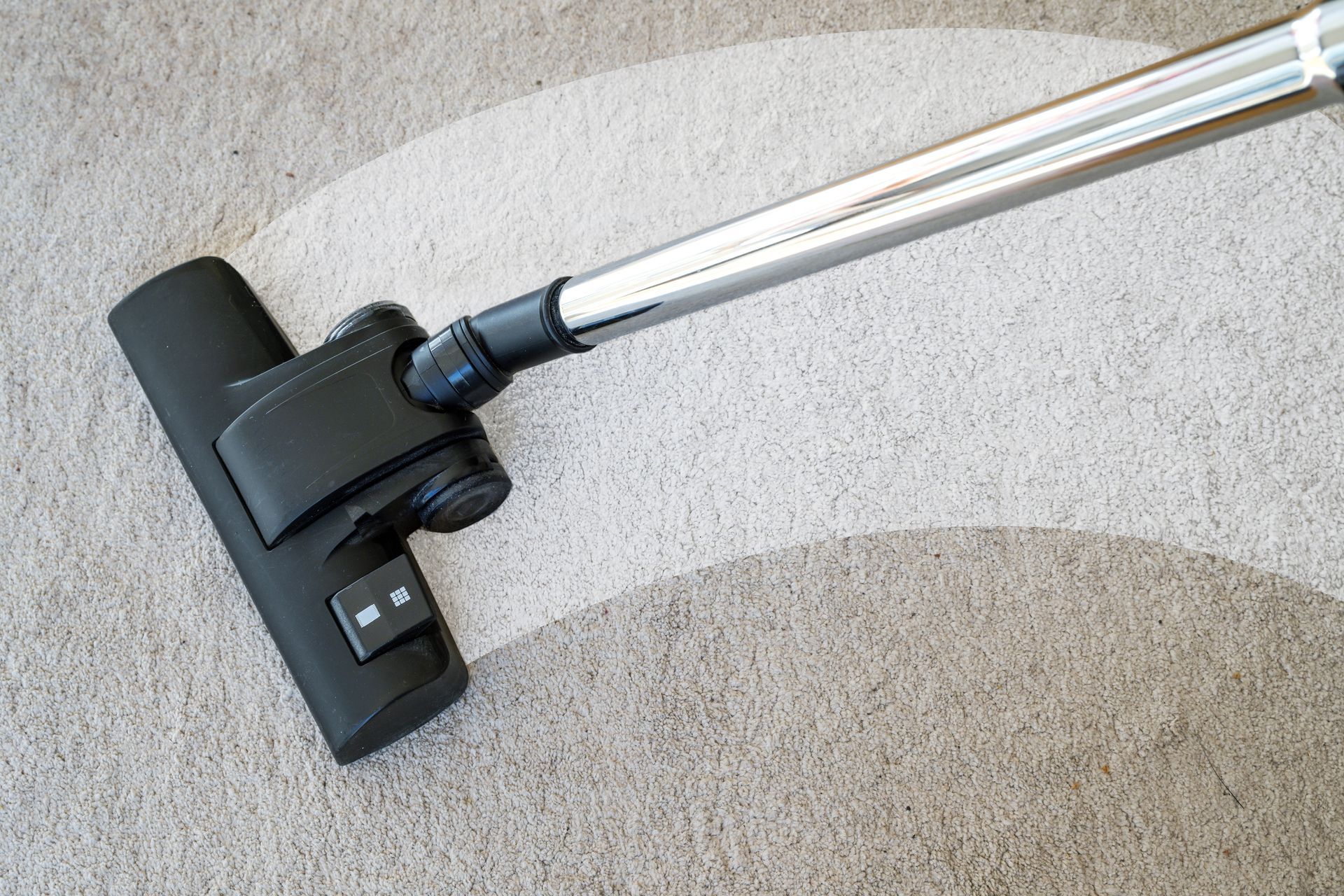A closeup of a vacuum being used for a carpet cleaning service.