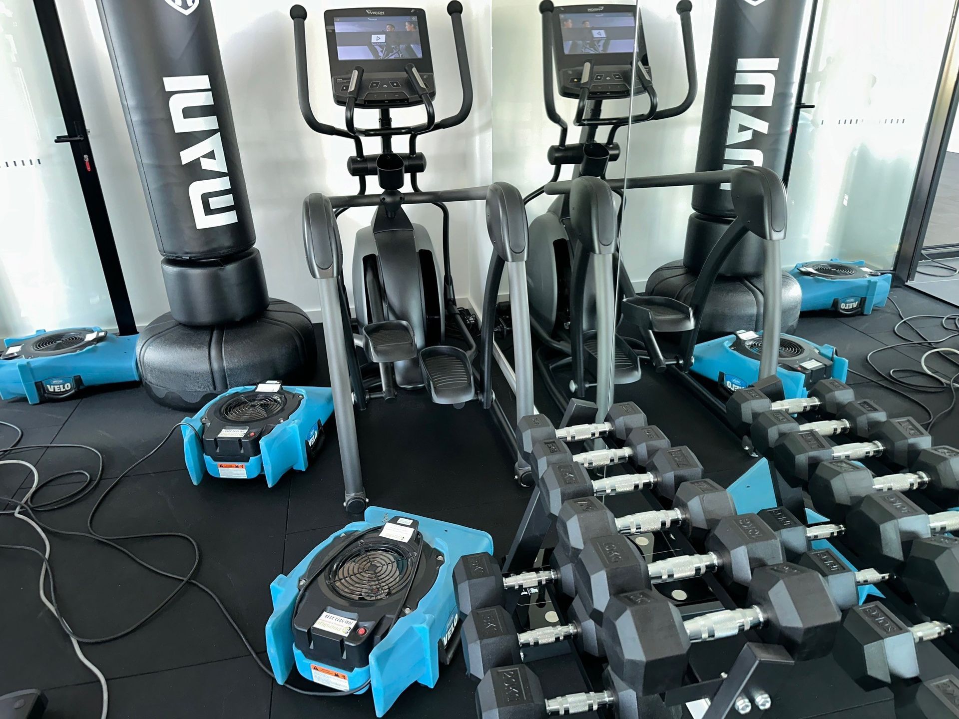 Two blue fans are sitting on the floor of a room.