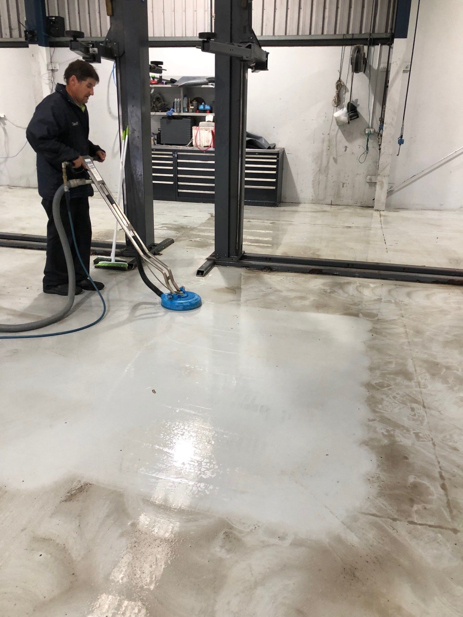 A woman is sitting on a couch in a living room with her hands behind her head.