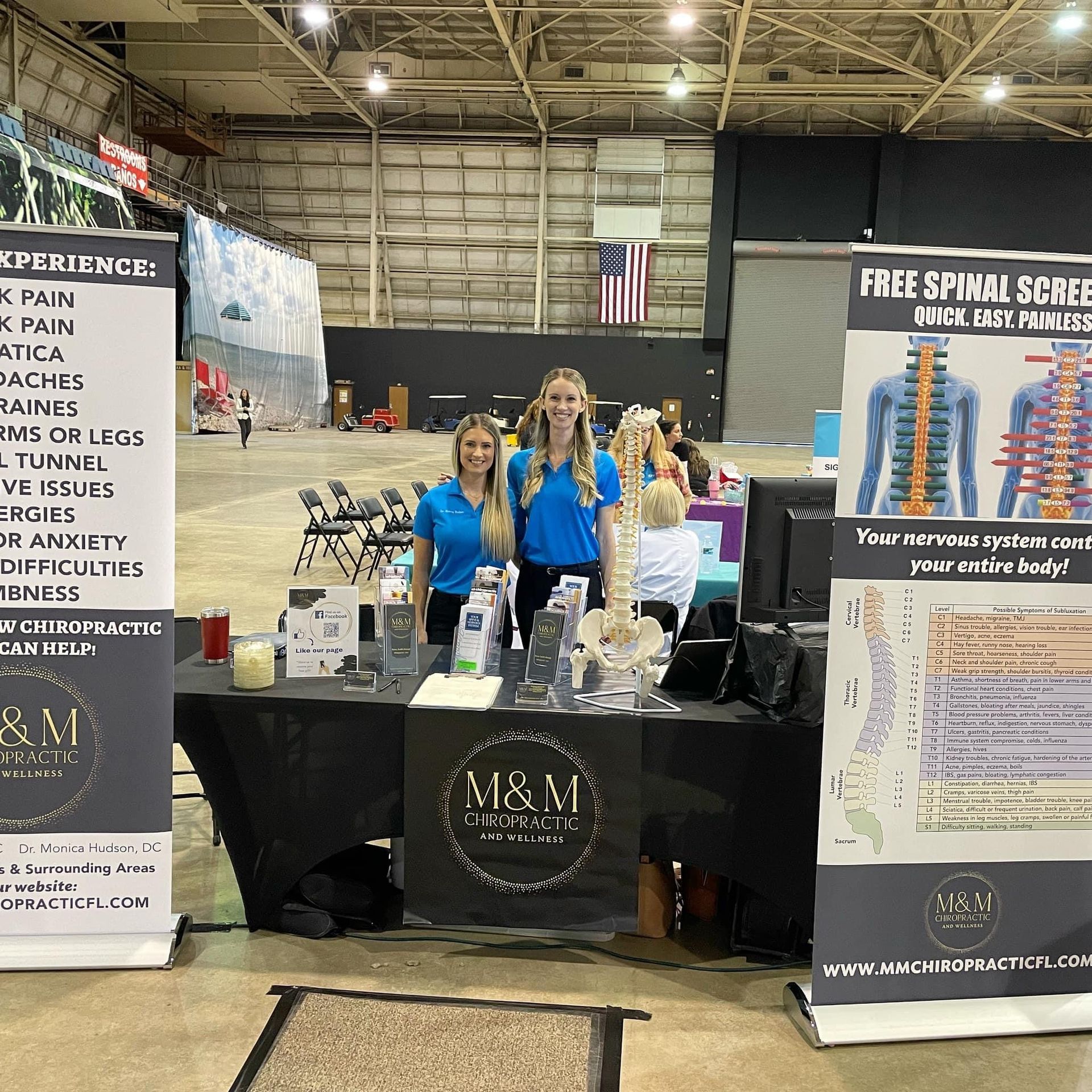 A group of people standing around a table with a sign that says free spinal screening