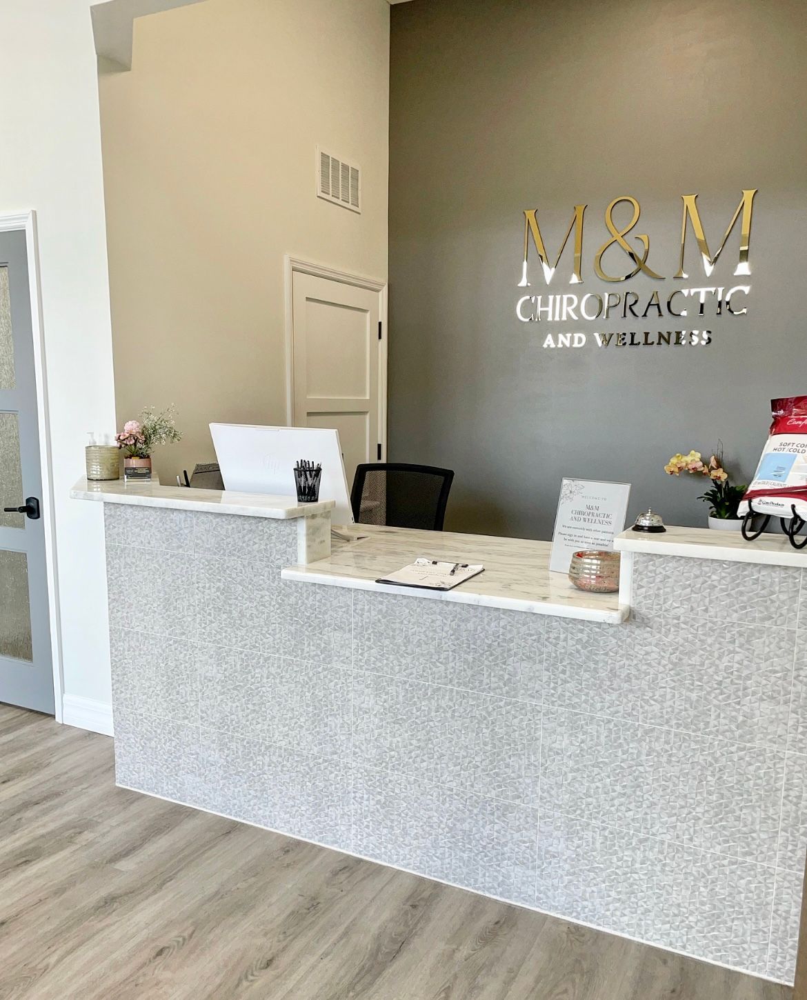 A reception desk in a chiropractic office with a computer on it.