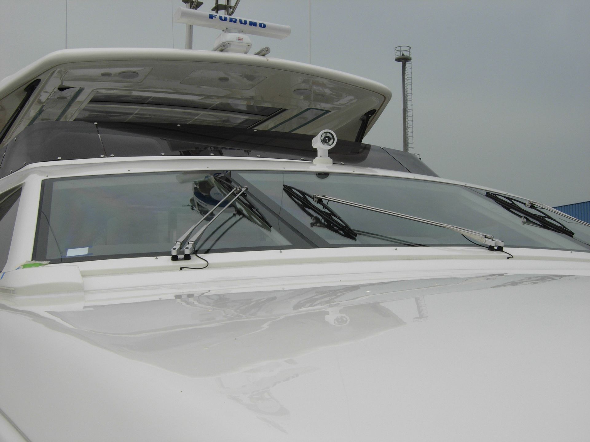 Imbarcazione bianca con tergicristalli, radar e strumentazione per la navigazione marittima.