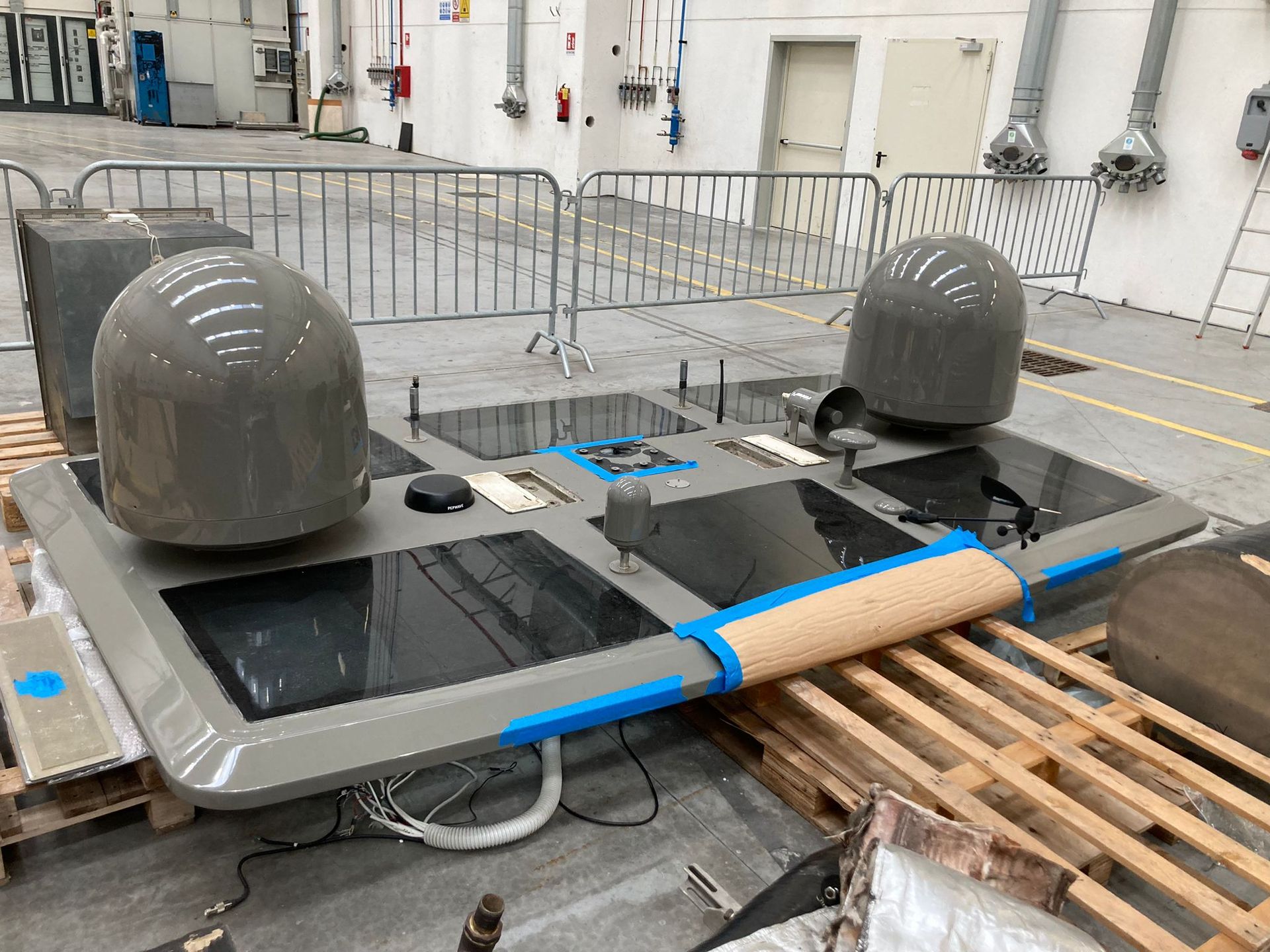 Grande attrezzatura rettangolare grigia con cupole arrotondate e pannelli neri, all'interno.