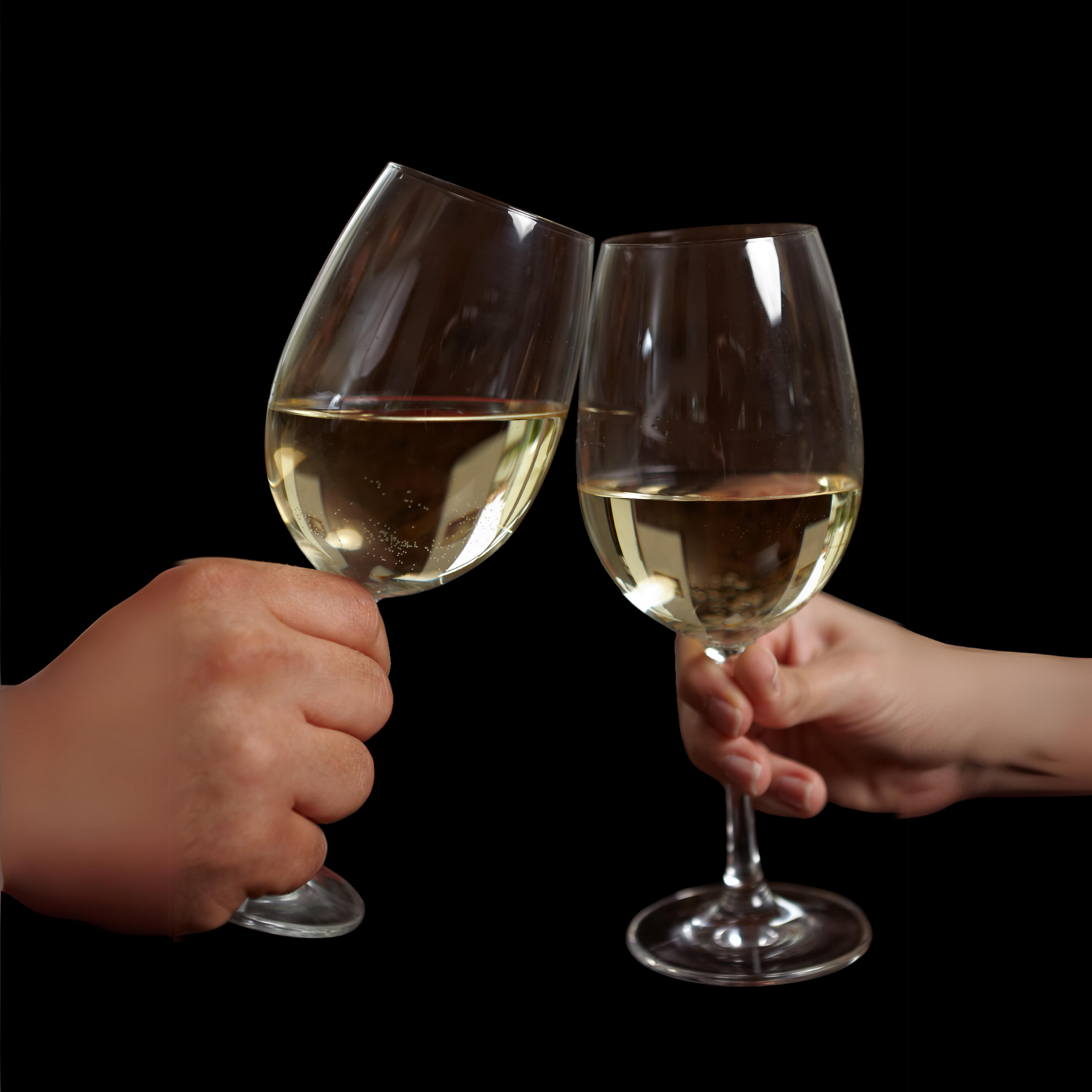 Two hands clink wine glasses filled with white wine against a black background.