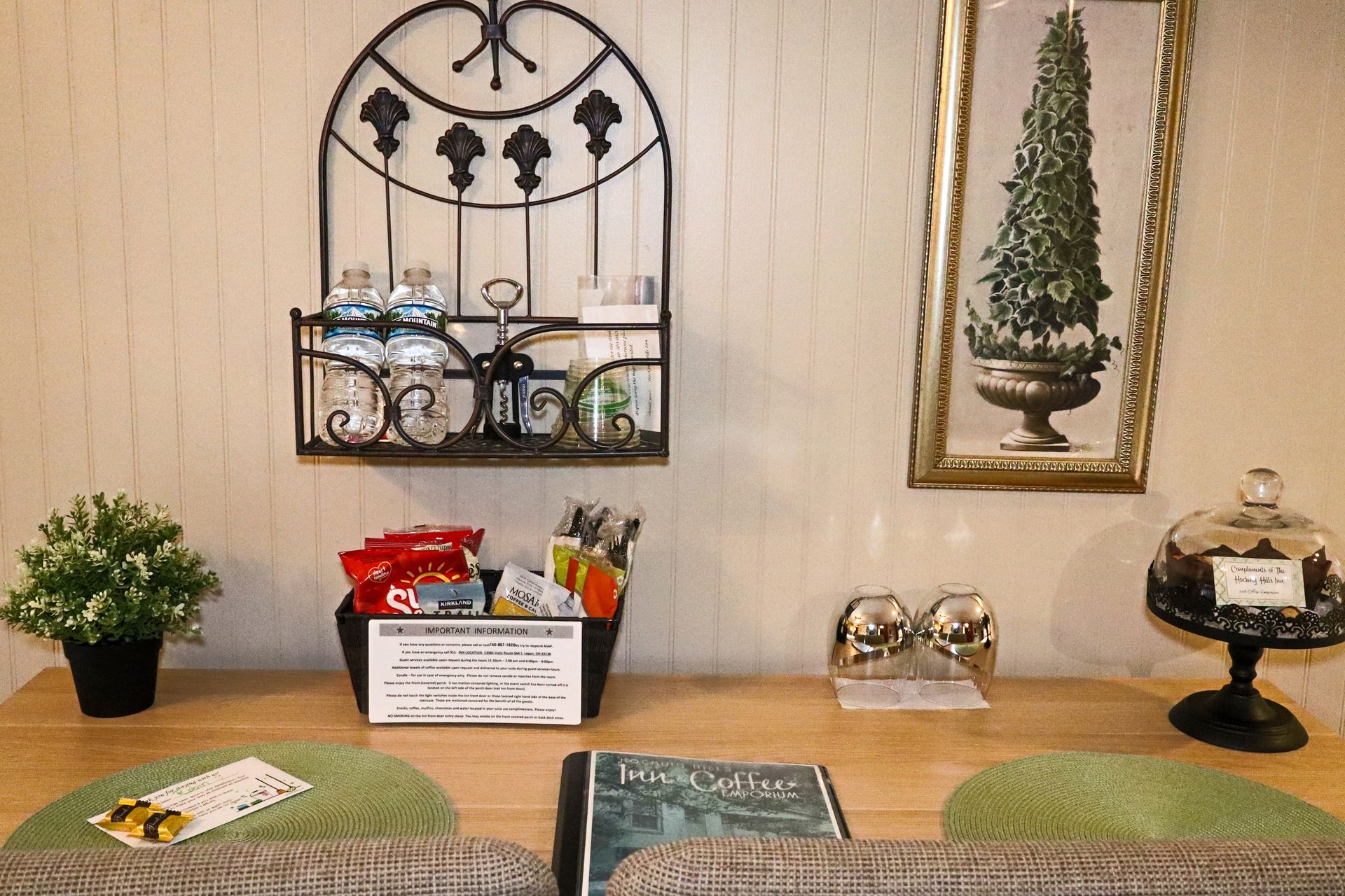 A snack and refreshment station on a wooden table. Includes a water bottle rack and basket of snacks