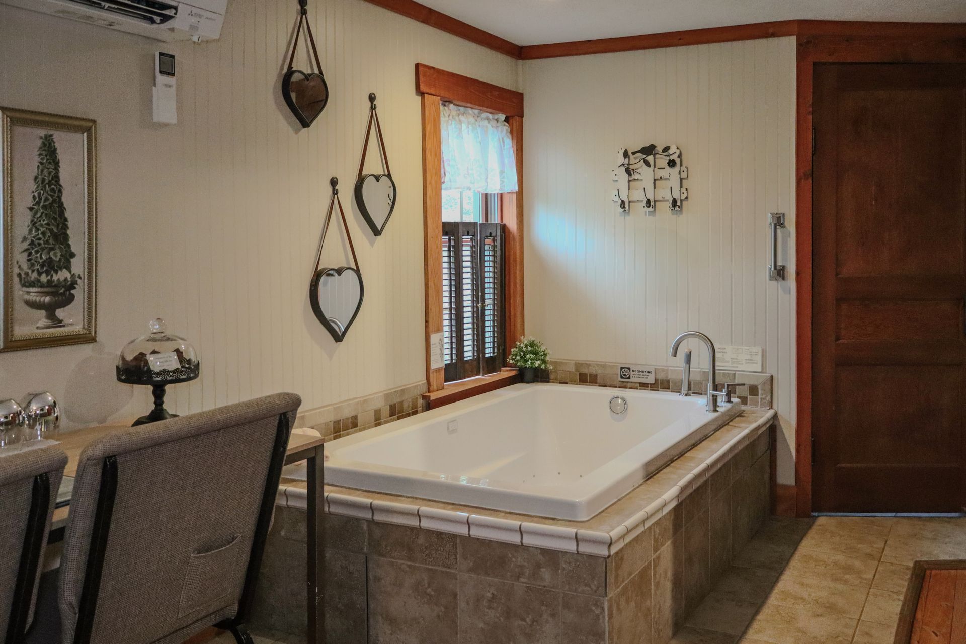 Bathroom with built-in rectangular tub, framed window, and light beige tiling.