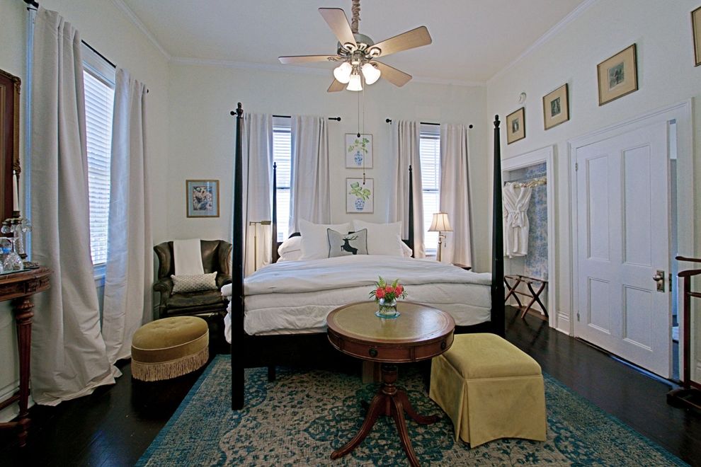 A bedroom with a four poster bed and a ceiling fan