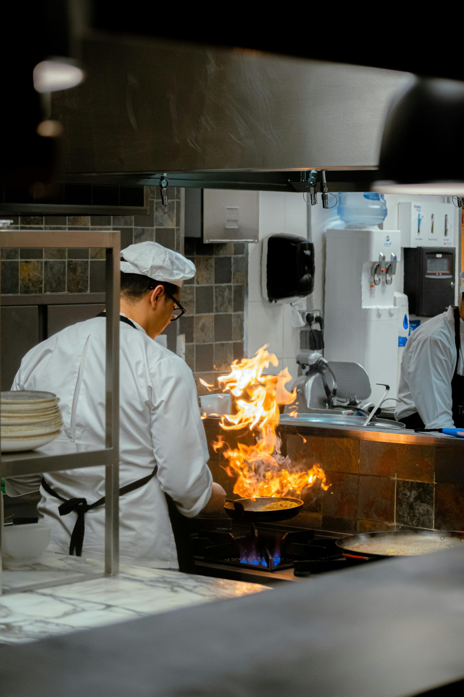 A person is cooking eggs in a frying pan on a stove.