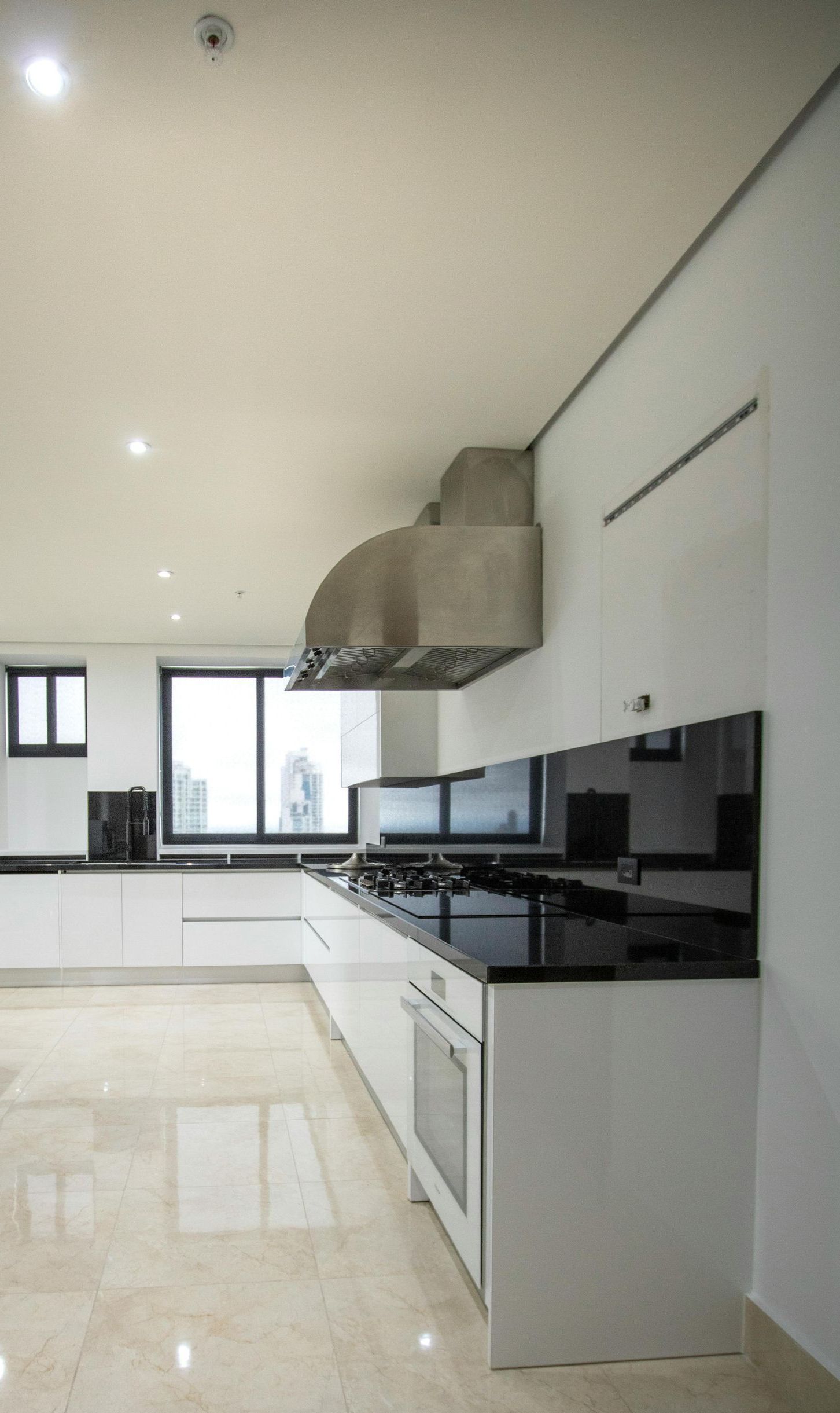 A kitchen with white cabinets and black counter tops.