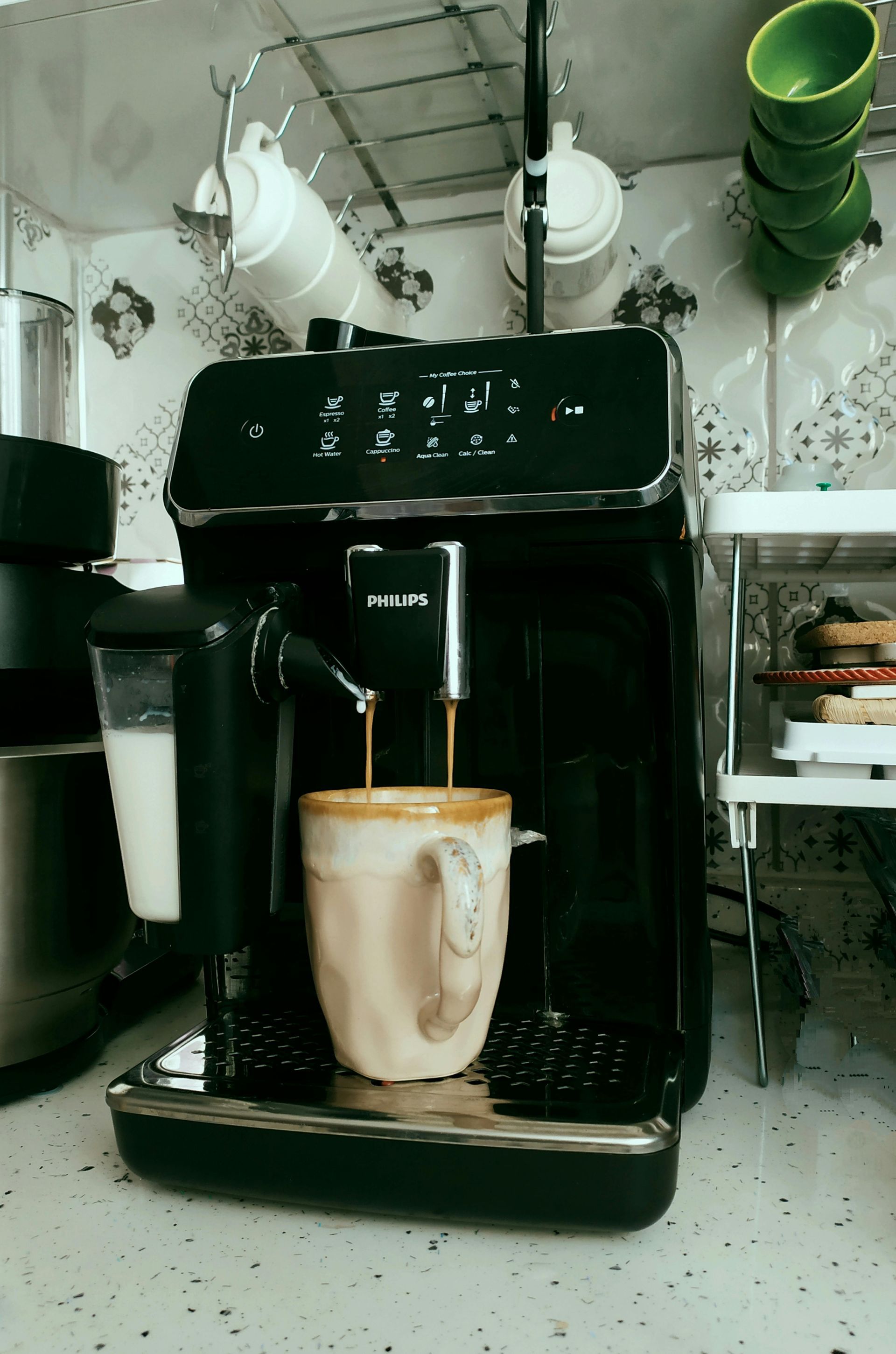 A cup of coffee is being poured into a coffee machine.