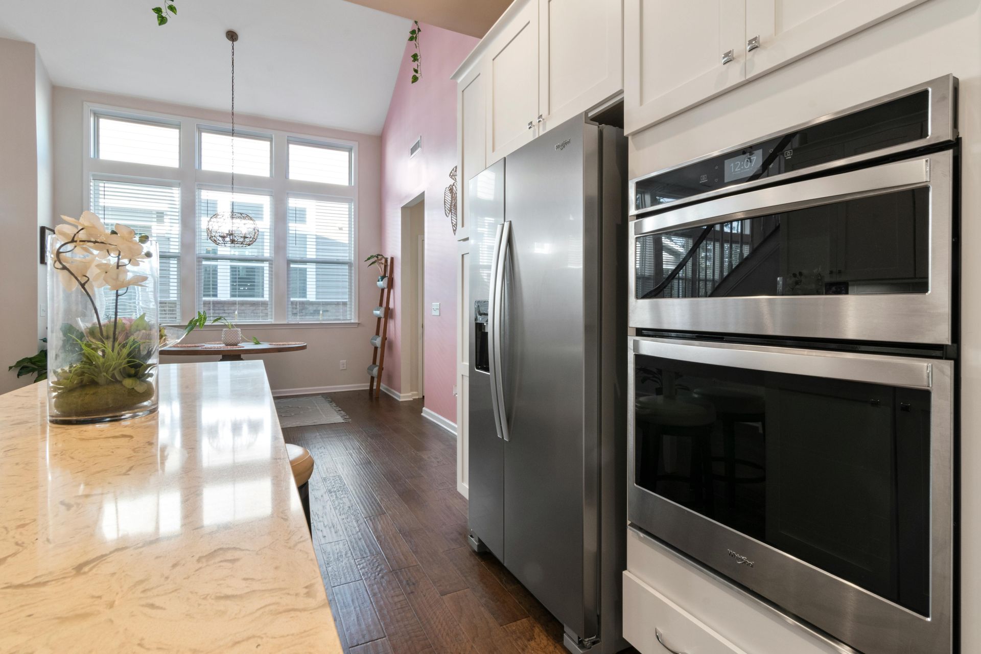 A kitchen with stainless steel appliances and white cabinets.