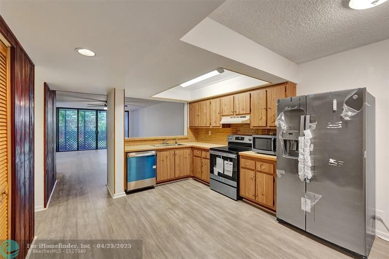 A kitchen with stainless steel appliances and wooden cabinets