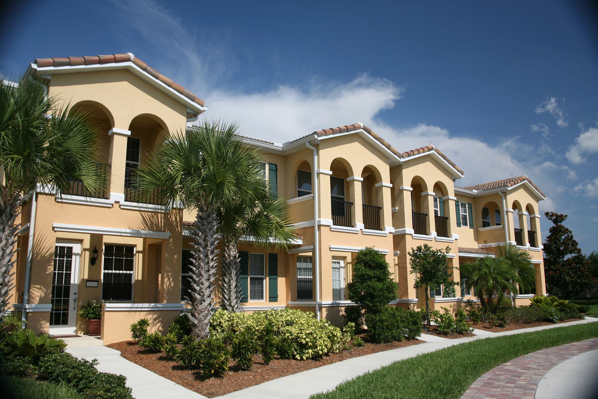 A large apartment building with palm trees in front of it