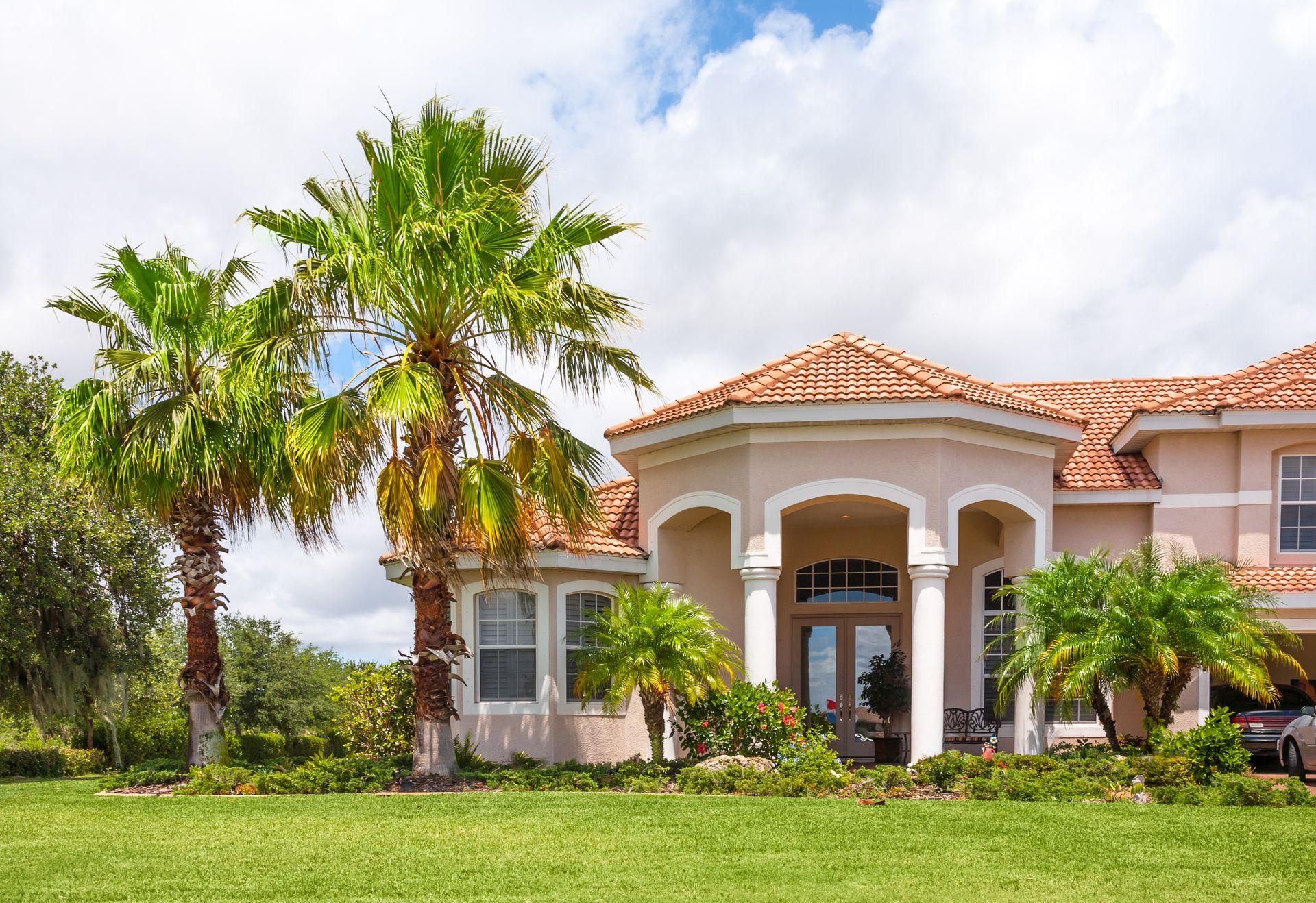 A large house with palm trees in front of it.