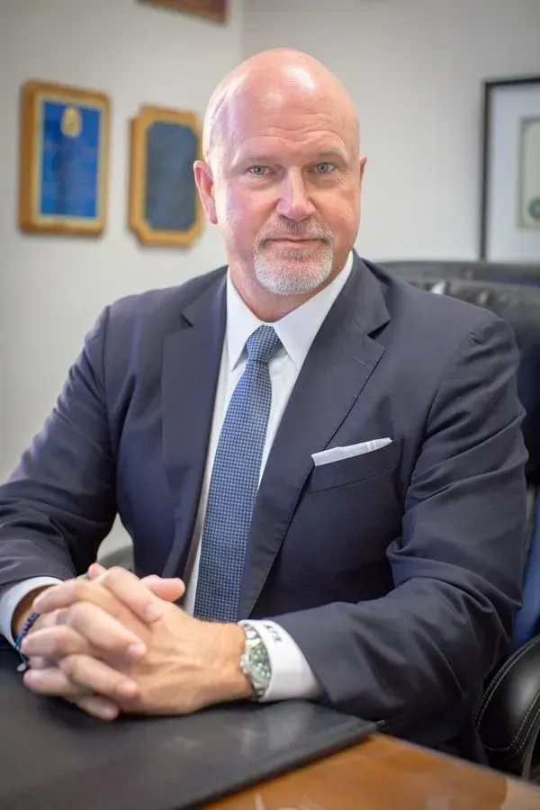 A woman in a blue jacket is smiling for the camera.