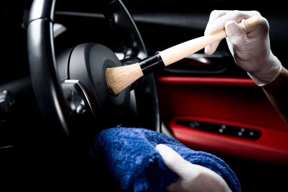 A Person Is Cleaning The Steering Wheel Of A Car With A Brush β Townsville Car Care Centre In Aitkenvale, QLD