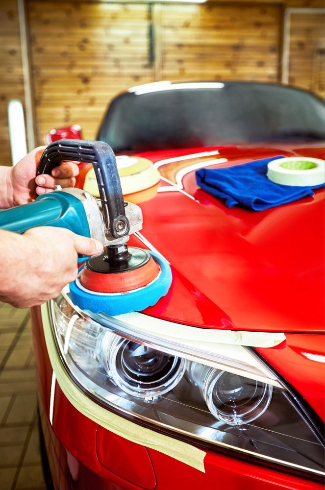 A Person Is Polishing A Red Car With A Machine — Townsville Car Care Centre In Aitkenvale, QLD