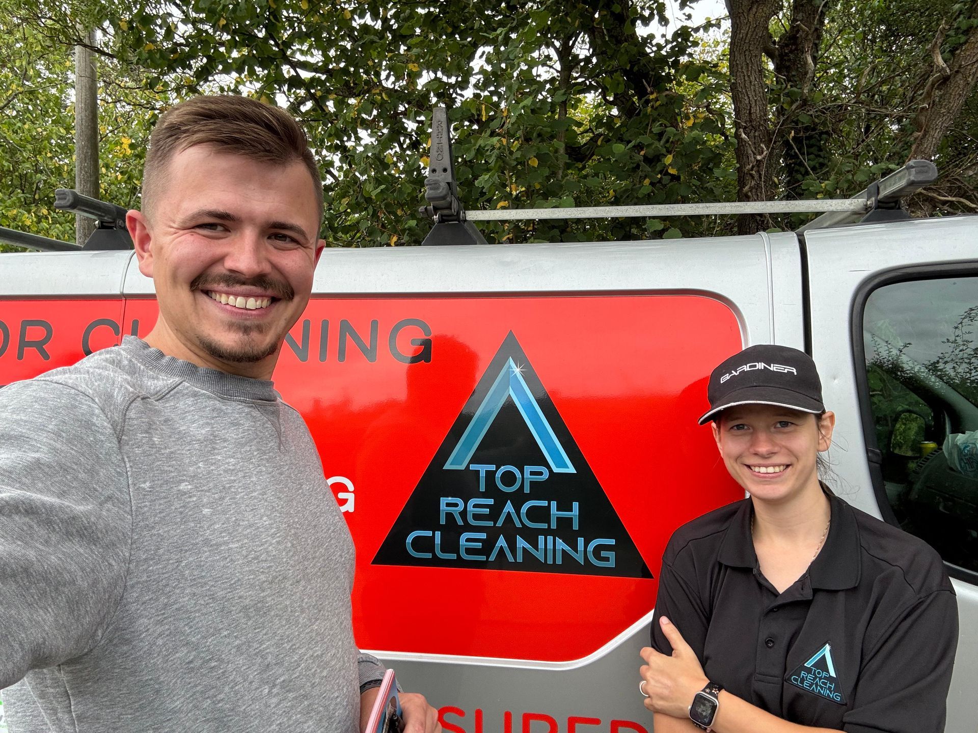 Image of Simon & Paulina in front of Top Reach Cleaning Logo