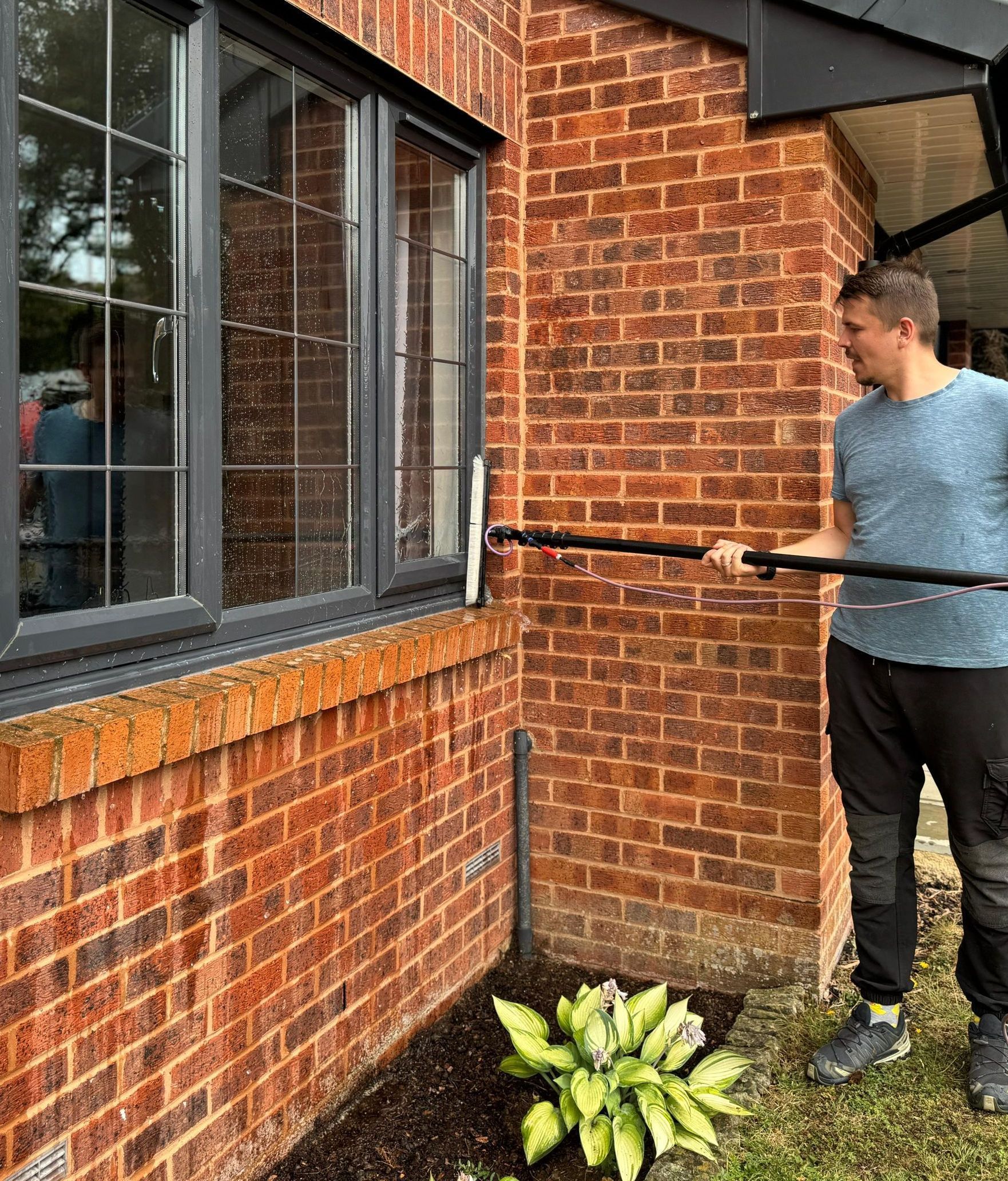 Man window cleaning with pole