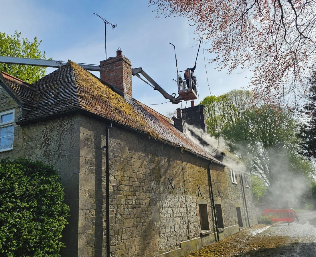 Roof Steam Cleaning on old building with cherry picker