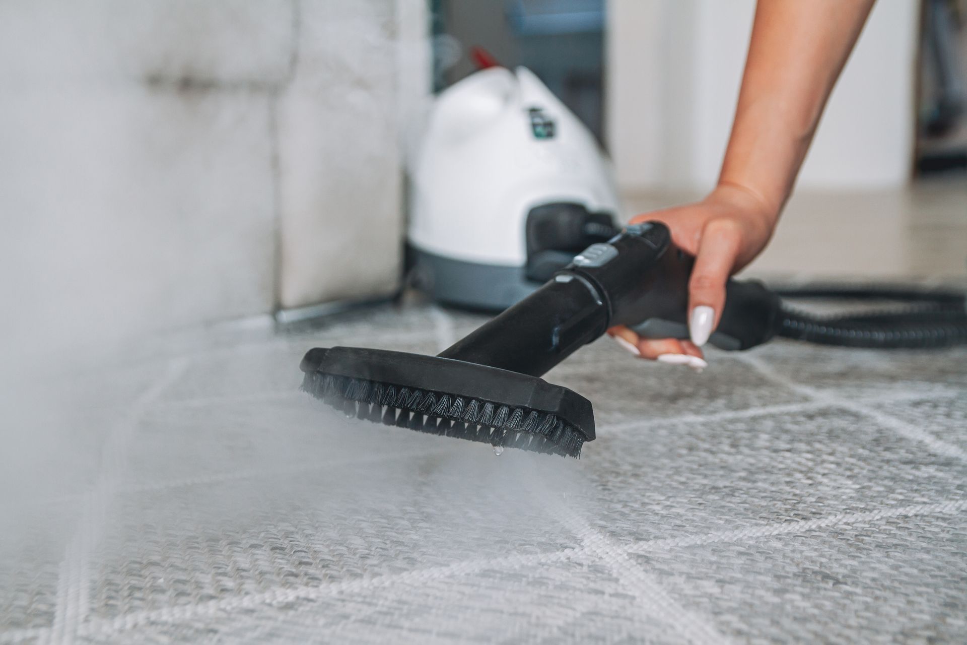 A woman cleaning carpet with a steam cleaner