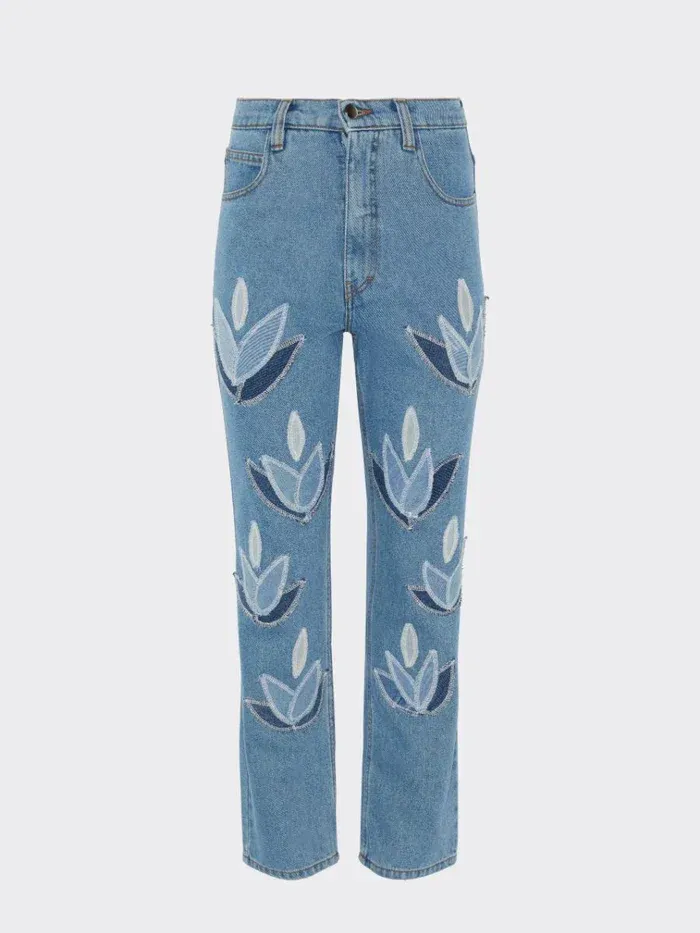 a pair of blue jeans with white flowers on them .
