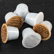 A group of coffee capsules sitting on top of each other on a table.