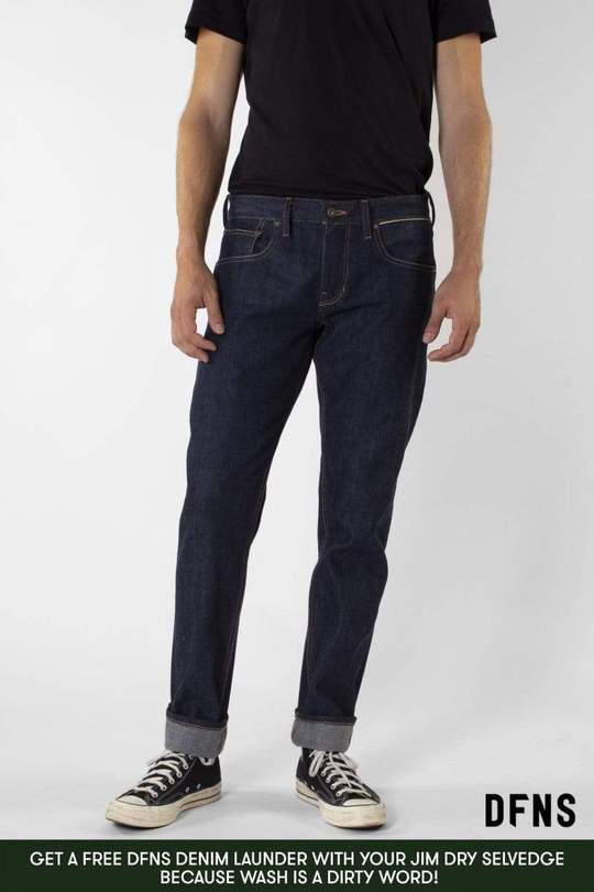 A man is wearing a black shirt and blue jeans.