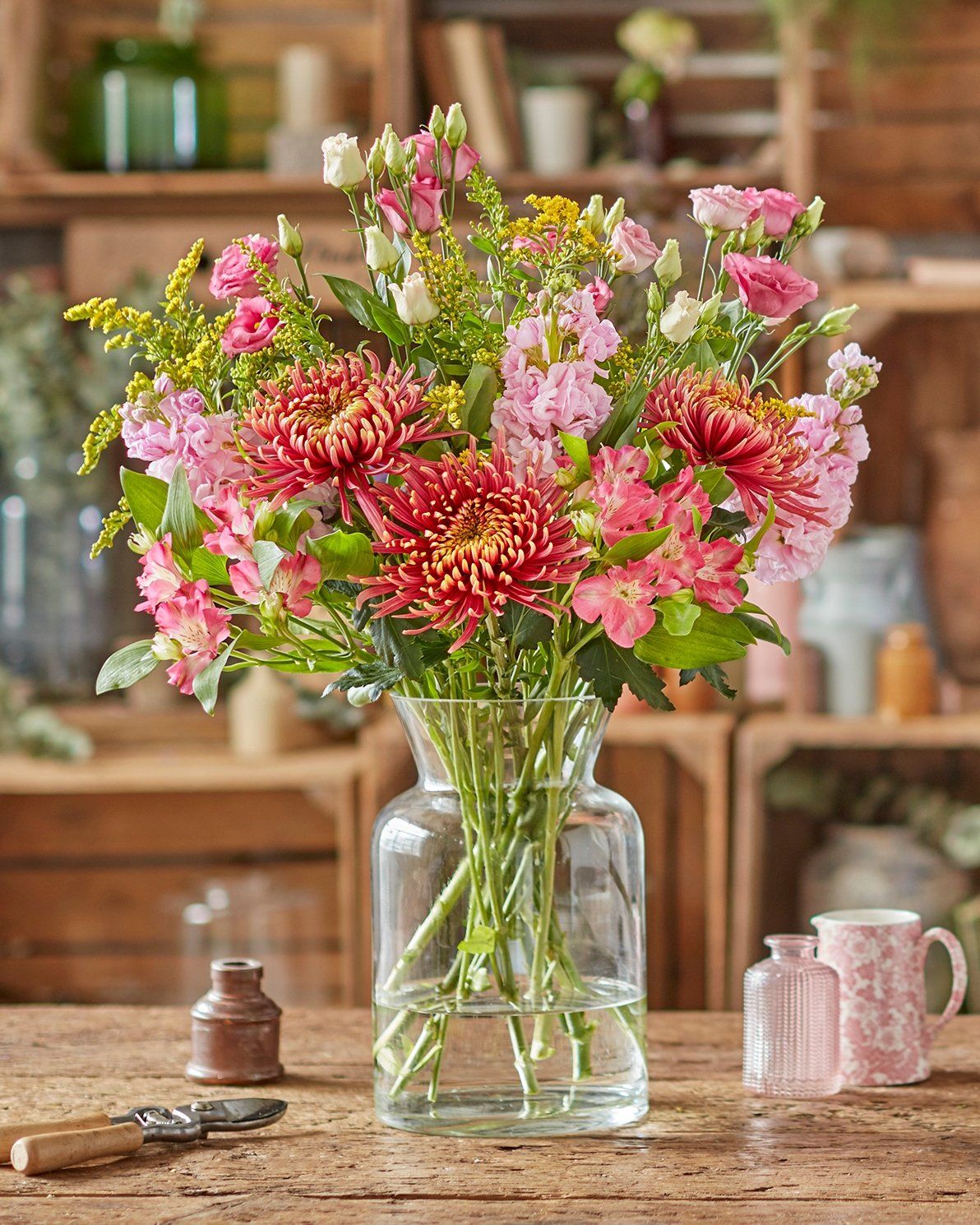 A vase filled with flowers is sitting on a wooden table.