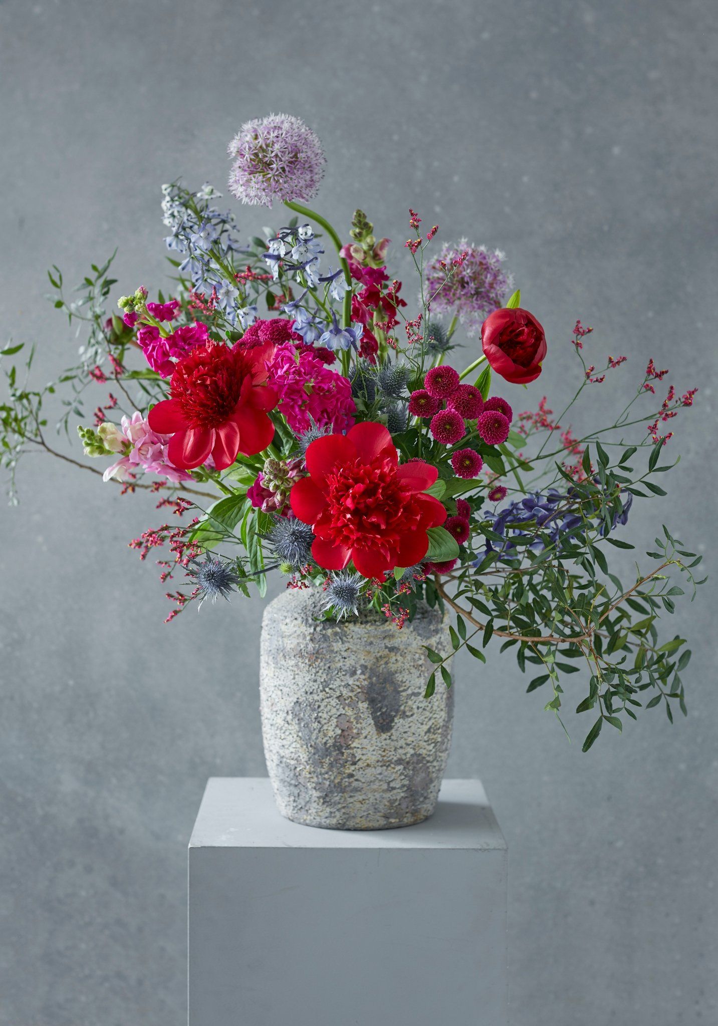 A vase filled with red and blue flowers is sitting on a table.