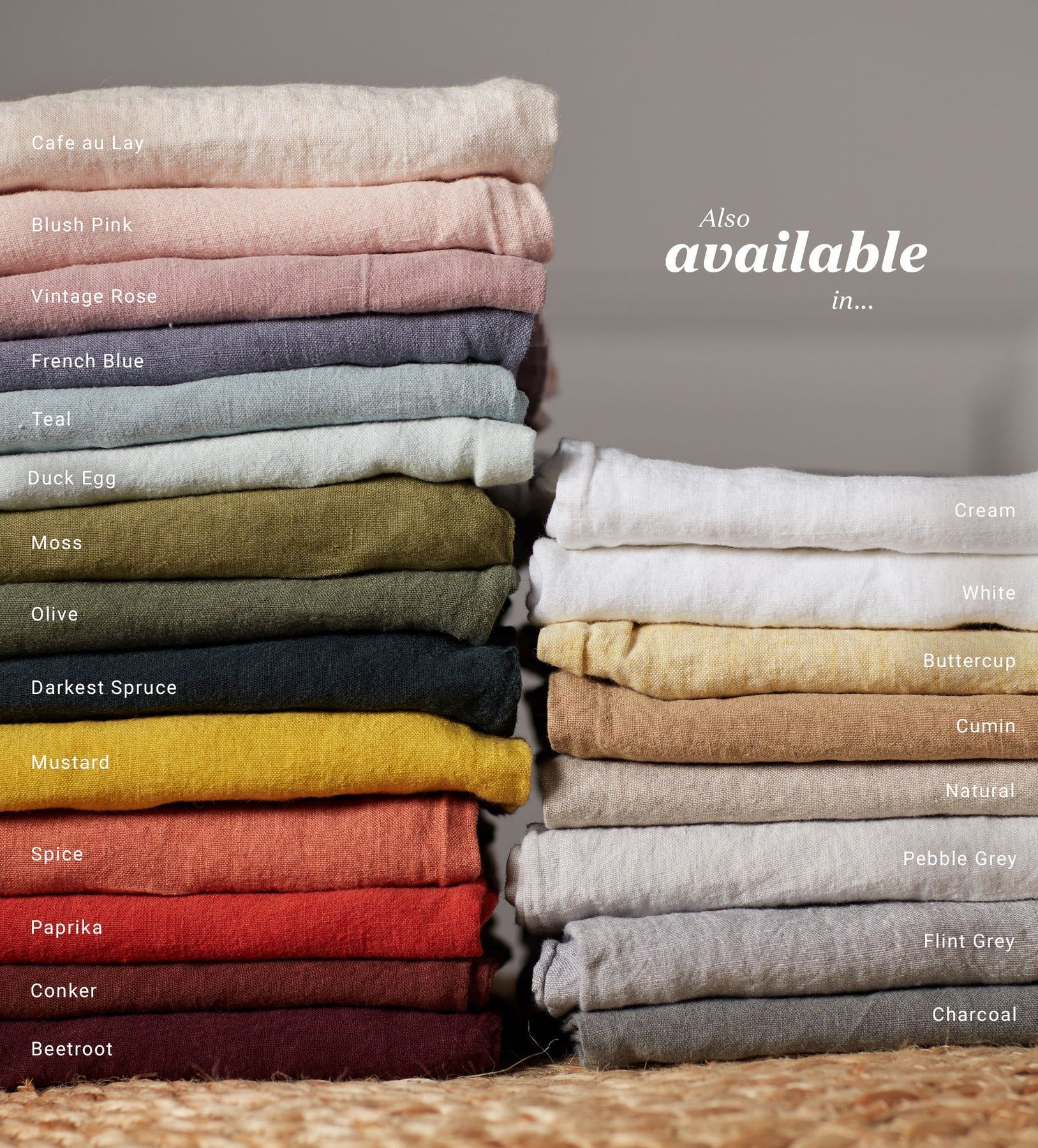A stack of linen bedding of different colours are sitting on top of each other on a table.