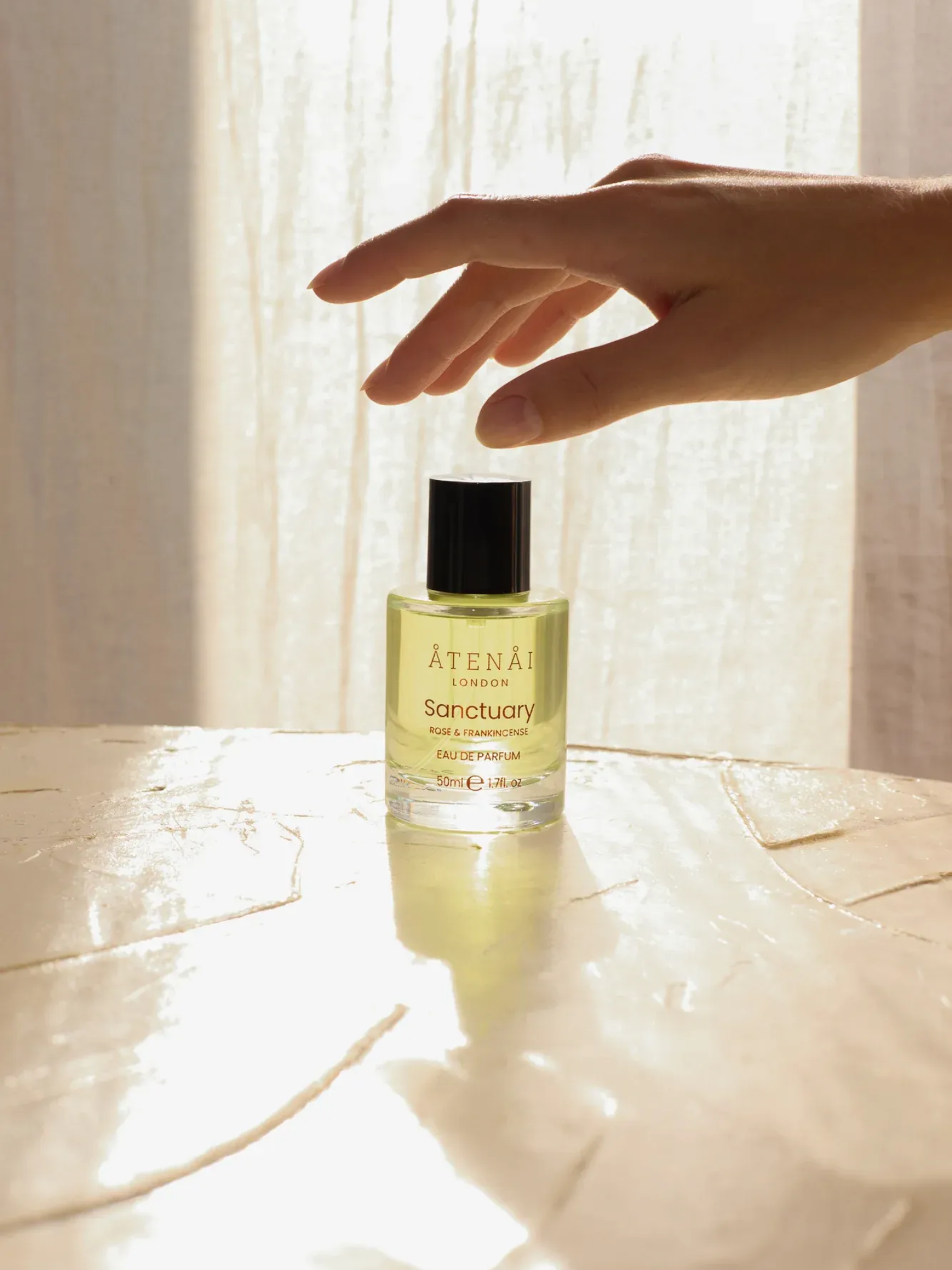 A wooden box filled with bottles of various perfumes on a wooden table.