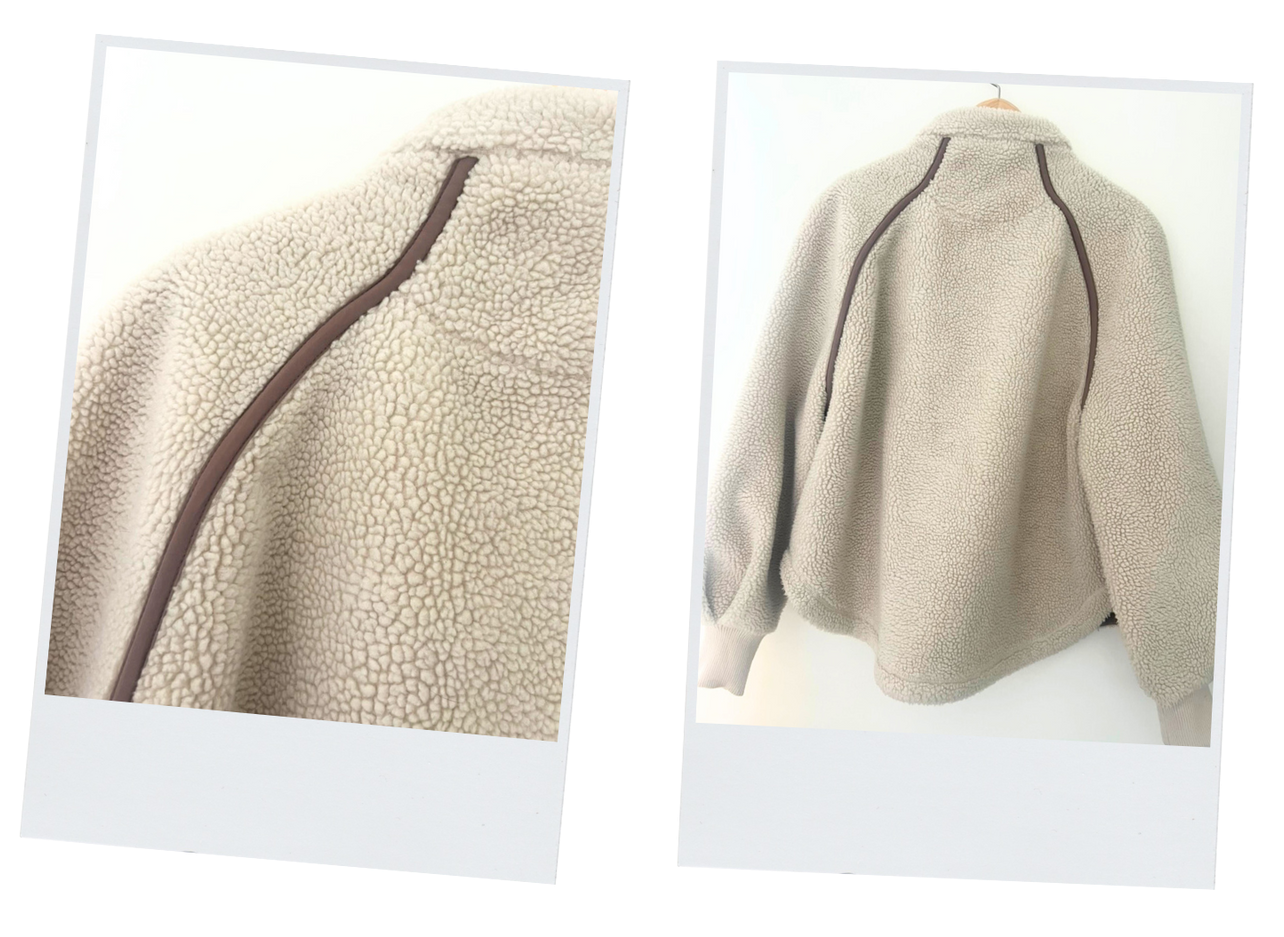 Three photos of a beige sherpa fleece jacket with brown trim, zipper, and a logo patch. The jacket is shown open, closed, and close-up.