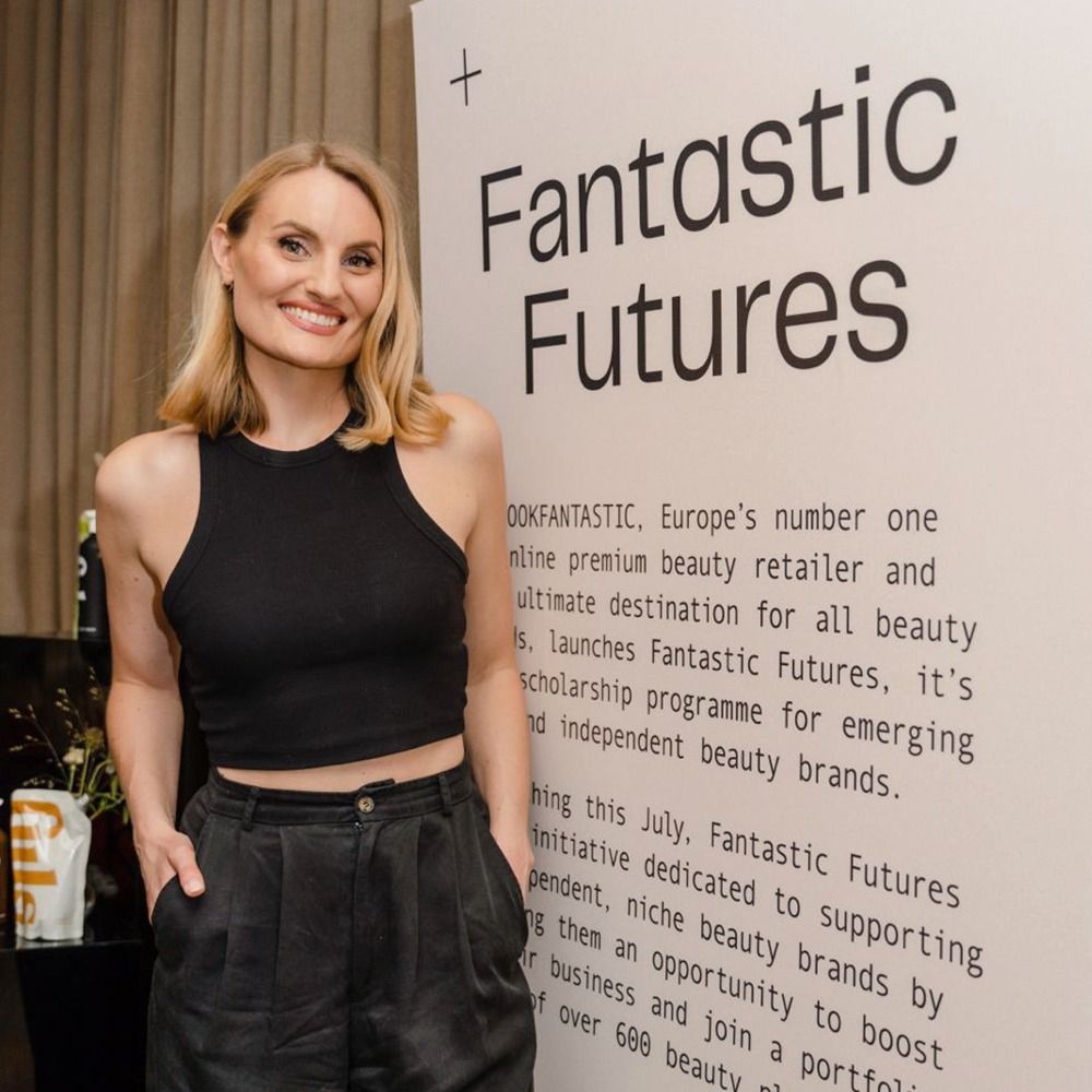 Anna Priadka stands in front of a sign that says fantastic futures