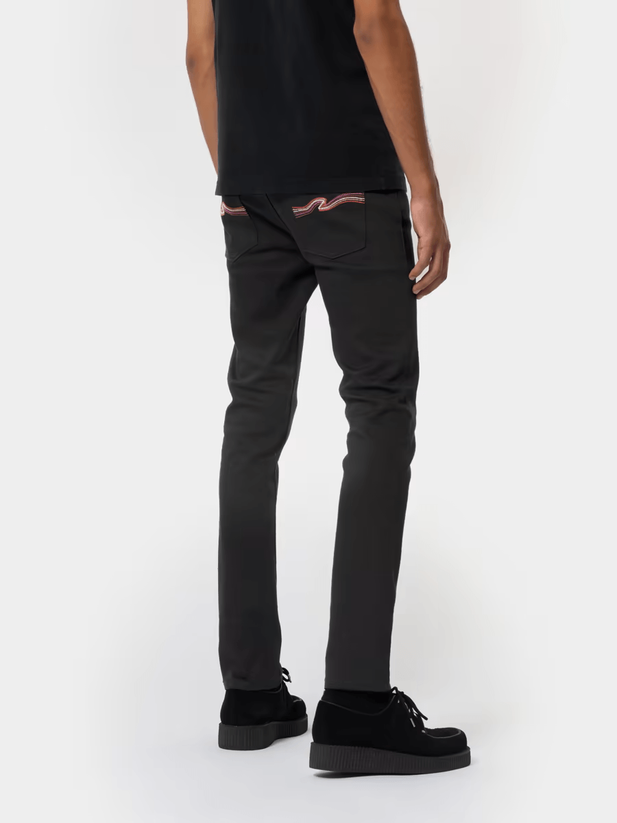 A man is wearing a black shirt and black jeans.