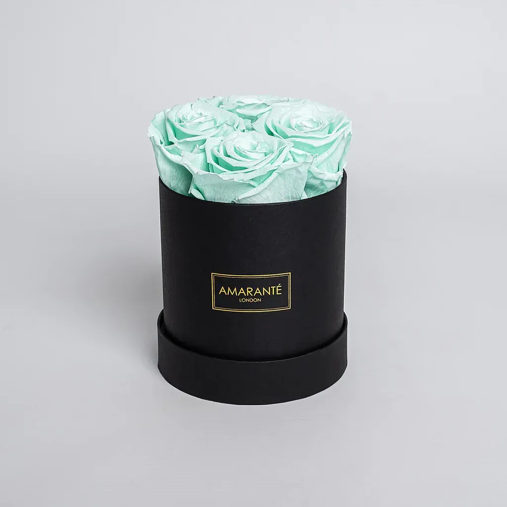 A black box with mint green roses in it
