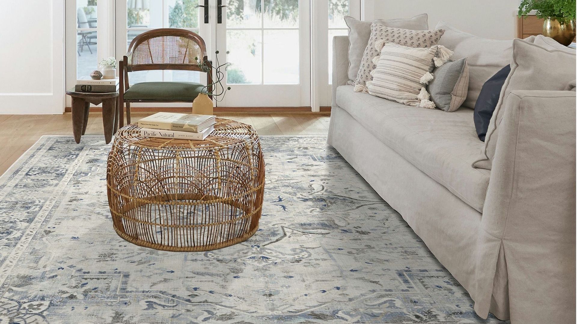 A living room with a couch , chair , coffee table and rug.