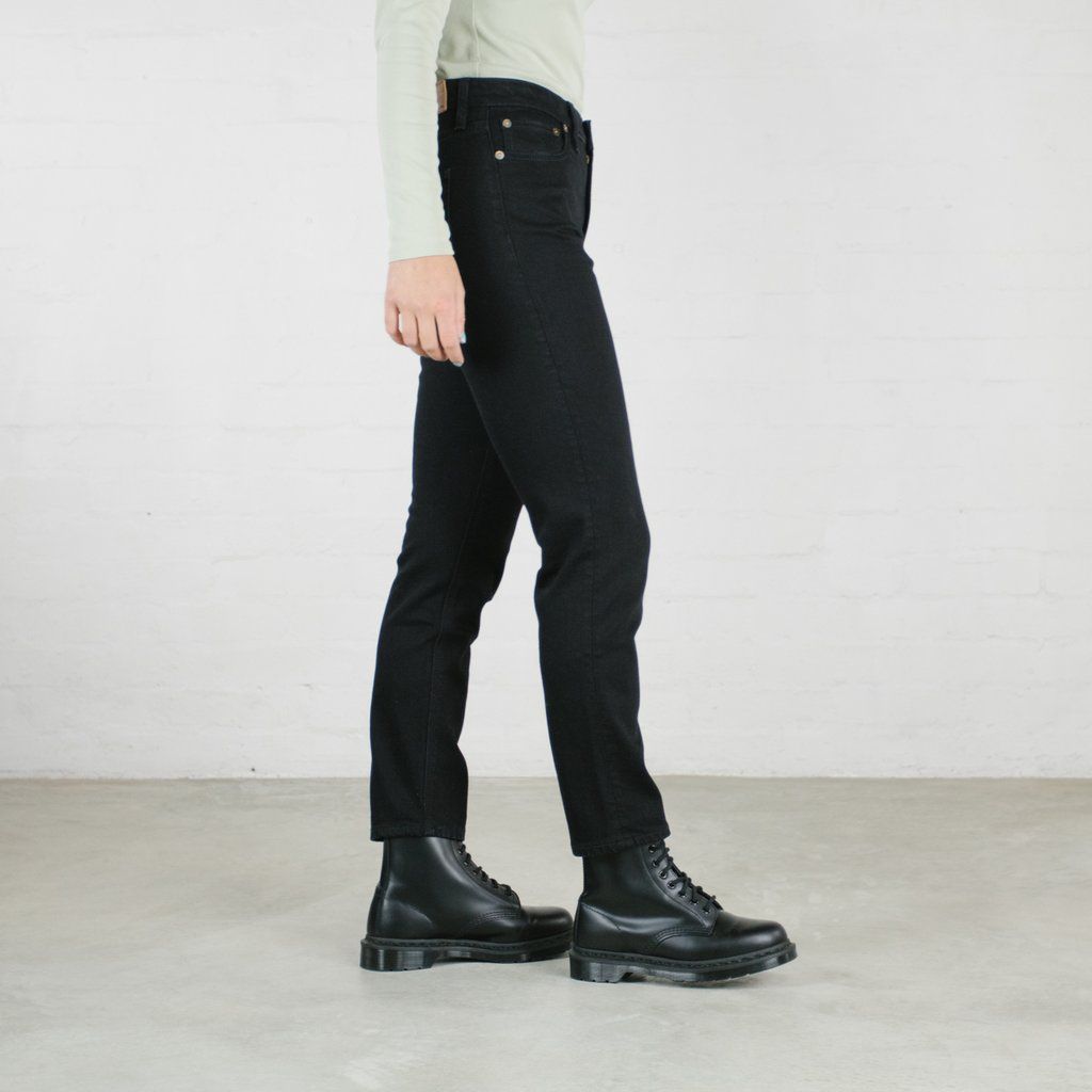 A person wearing black pants and black boots